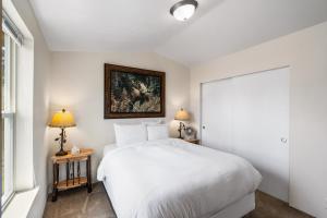 a bedroom with a white bed and a painting on the wall at Alpine #1 in West Yellowstone