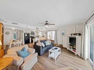 a living room with a couch and a table at Island North 14C - 2nd row stunner! Relax in comfort after your days in the sun condo in Carolina Beach