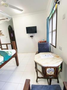 Habitación con cama, mesa y silla en Garden Lodge, en Zanzíbar