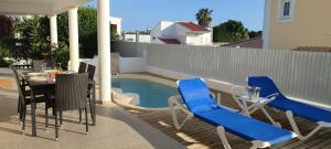 a patio with a table and chairs and a pool at Casa da Amoreira in Alvor