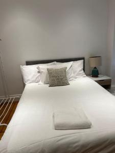 1 cama blanca grande con 2 almohadas en Lovely London Apartment, en Londres