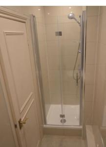 y baño con ducha y puerta de cristal. en Lovely London Apartment, en Londres