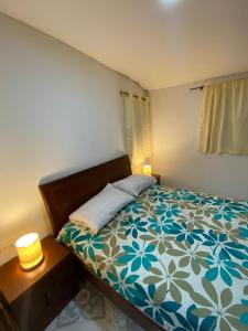 a bedroom with a bed with a blue and white comforter at Miss Titi's Native Lodge in San Andrés