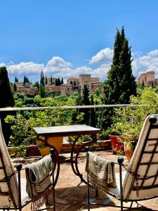 a table and chairs on a patio with a view of a city at Duplex vistas Alhambra in Granada