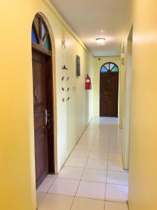 an empty hallway with a door and a tile floor at Garden Lodge in Zanzibar City