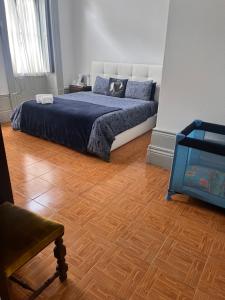 een slaapkamer met een bed en een houten vloer bij Residência Céu Azul in Porto