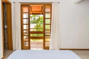Schlafzimmer mit einer Tür, die auf einen Balkon führt in der Unterkunft Cruz House in Florianópolis