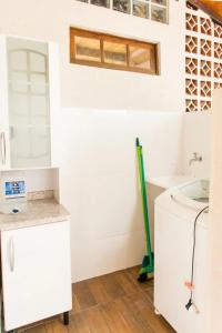 ein Badezimmer mit einem Waschbecken und einem Mopp in der Unterkunft Cruz House in Florianópolis