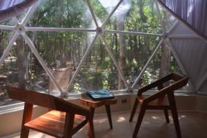 a room with a large window with a table and a chair at Glamping Mayan Glam in Tulum