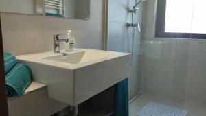 een witte badkamer met een wastafel en een douche bij Moni in Aprilia Marittima