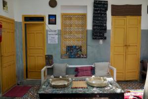 a room with a table and some yellow doors at The Madrassa in Marrakesh