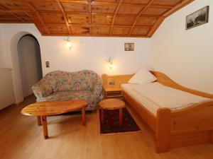 a bedroom with a bed and a couch and a table at Enzianhof in Silbertal