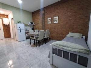 a bedroom with a bed and a table and a kitchen at AMALIA departamentos in San Rafael