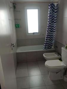 łazienka z wanną, toaletą i oknem w obiekcie Departamento el estadio w mieście Santiago del Estero