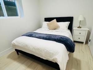 a bedroom with a bed with a blue blanket on it at New 2 bedrooms King & Queen beds Guest suite in Surrey