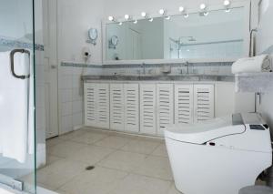 a bathroom with a toilet and a sink and a mirror at Hotel Zaracay in Santo Domingo de los Colorados