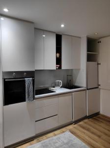 プリシュティナにあるMSM-apartmentの白いキャビネットと冷蔵庫のあるキッチン +15枚の写真