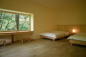 two beds in a room with a window at Shiroyamakan in Shirakawa +47 photos