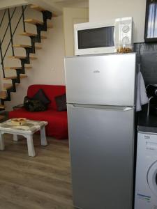 a kitchen with a refrigerator with a microwave on top of it at palalain appartement in Tarbes