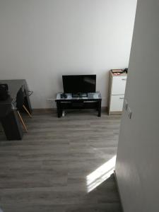 a living room with a flat screen tv and a table at palalain appartement in Tarbes