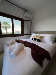 a bedroom with a large bed with white sheets and pillows at Hacienda ZK in Nea Potidaea