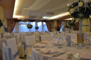 a banquet hall with white tables and white chairs at Hotel Petrarca in Boara Pisani