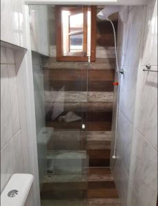 ein Bad mit Dusche, WC und Fenster in der Unterkunft Cruz House in Florianópolis