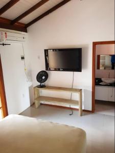 ein Wohnzimmer mit einem Flachbild-TV an der Wand in der Unterkunft Cruz House in Florianópolis