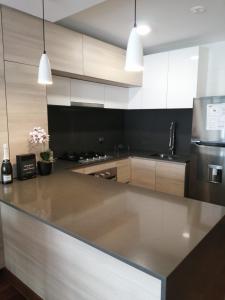 cocina con armarios blancos y nevera de acero inoxidable en EL PRAT Luxury Aparment Lima Peru, en Lima