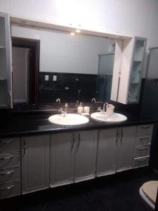 een badkamer met 2 wastafels en een grote spiegel bij Chácara de luxo aconchegante no centro de Socorro! in Socorro