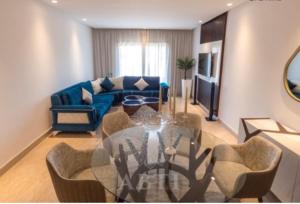a living room with a glass table and a blue couch at Incantevole Luxury apprt nel cuore di Casablanca in Casablanca