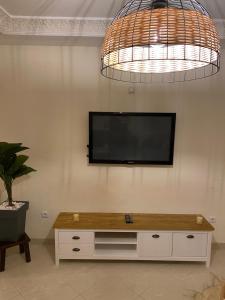 a living room with a television on a wall at Appartement kenzi Beach in Tangier