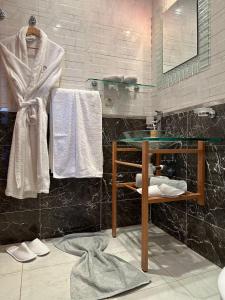 a bathroom with a sink and a mirror and towels at Prestigieux Appartement à Marina Assilah Golf in Asilah