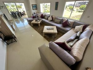 a living room with a couch and a table at Prestigieux Appartement à Marina Assilah Golf in Asilah