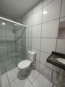 a white bathroom with a toilet and a sink at Pousada Central dos Lençóis in Barreirinhas