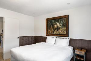 a bedroom with a white bed and a painting on the wall at Alpine #2 in West Yellowstone