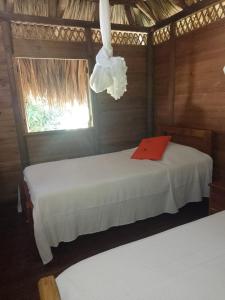 1 dormitorio con 2 camas y lámpara de araña en Cabaña Wiwa Tayrona, en Santa Marta