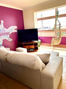 sala de estar con sofá y TV en Casas Jeronimos en Lourinhã