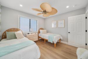 a bedroom with two beds and a ceiling fan at Luxury Villa 3 Blocks from the Beach with a Pool, Fire Pit and Outdoor Oasis in Cape Canaveral +32 photos