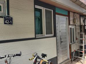 a bike parked outside of a house with a door at Camp k in Mokpo