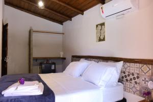 En eller flere senge i et værelse på Pousada Luz dos Olhos