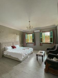 sypialnia z łóżkiem, kanapą i oknami w obiekcie VILLA TAZARZIT w Marakeszu