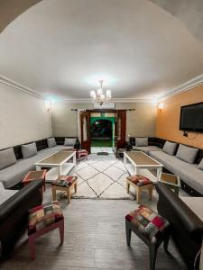 salon z kanapami, stołami i telewizorem w obiekcie VILLA TAZARZIT w Marakeszu