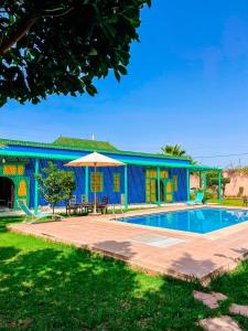 a blue house with a swimming pool in front of it at VILLA TAZARZIT in Marrakesh