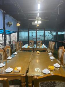 Golden Thai binh Hotel في Thái Bình: وجود طاولة وكراسي خشبية كبيرة في المطعم