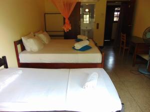 um quarto com 2 camas e uma sala de jantar em KOON COTTAGE em Kandy