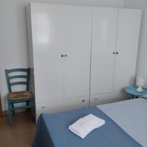 馬蒂納塔的住宿－Diomede Holiday Home，一间卧室配有蓝色的床和椅子