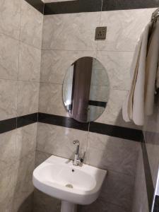 ein Bad mit einem Waschbecken und einem Spiegel in der Unterkunft Officer Condo Apartments in Yanyan