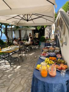 a table with a blue table cloth with fruit on it at Villa San Cosma in Ravello