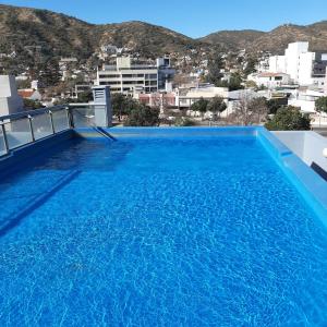 a large blue swimming pool on top of a building at Torre Myng in Villa Carlos Paz